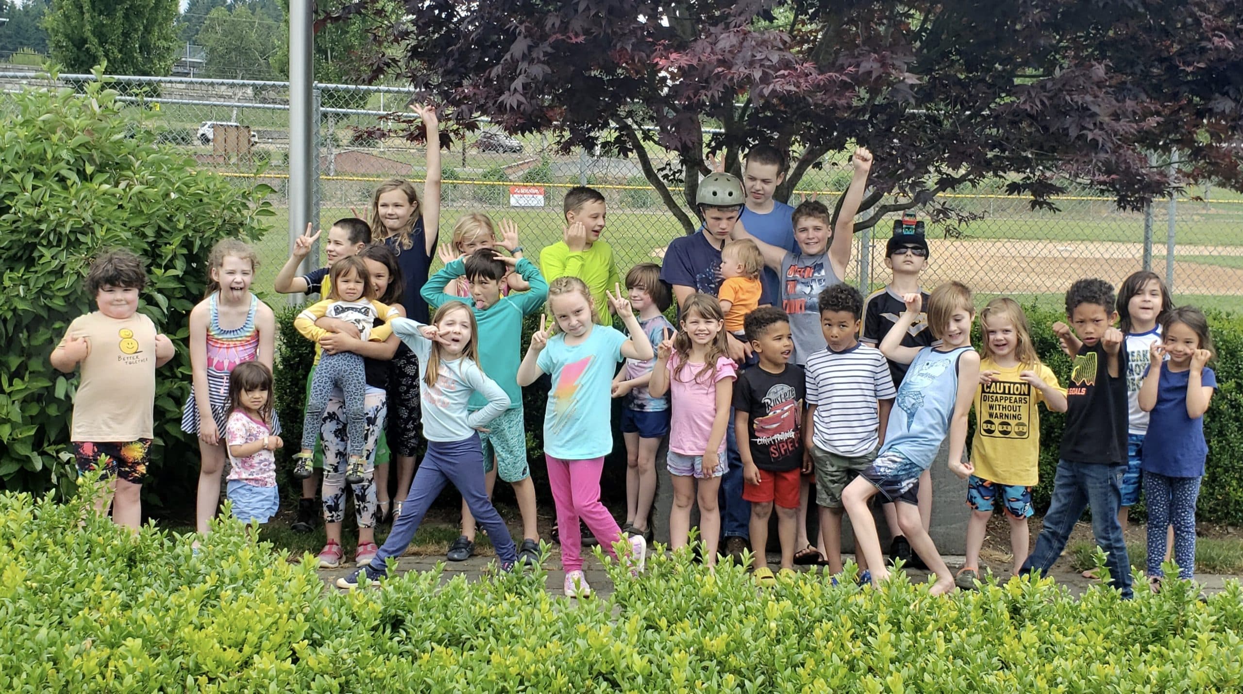 A large group of kids poses at a park