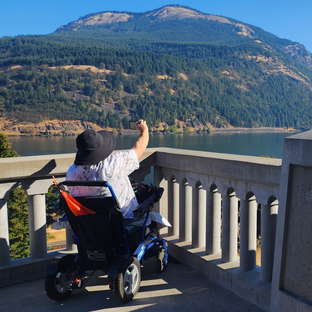 A woman in a wheelchair snaps a photo in the Columbia River Gorge