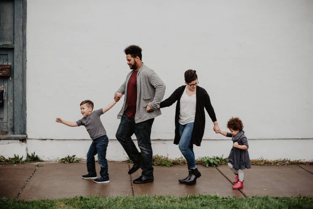 A family of four walks together hand-in-hand along a sidewalk. Find Southwest Washington family resources here.