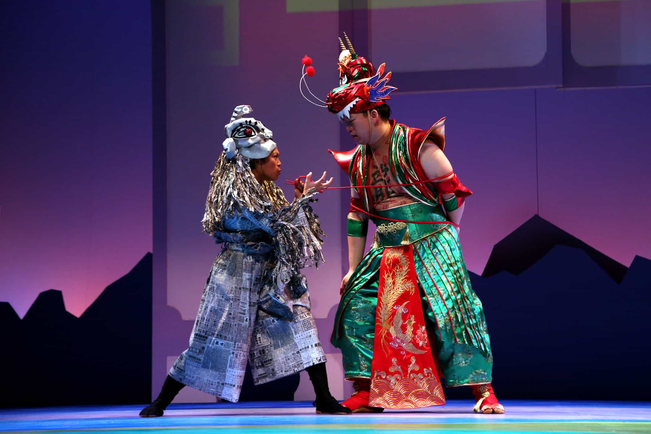 Characters on stage performing "Where the Mountain Meets the Moon" wear colorful costumes
