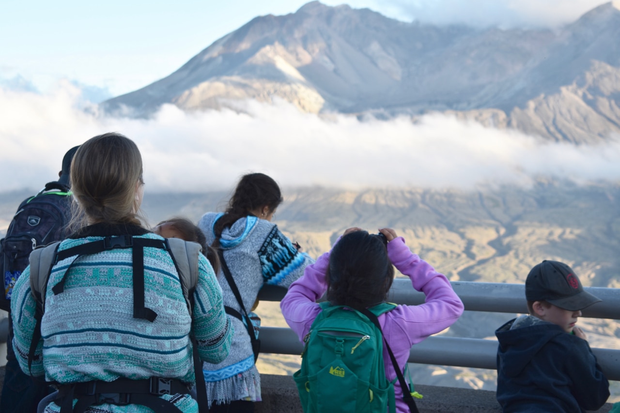 5 people look out over a railing at Mount St Helens's crater