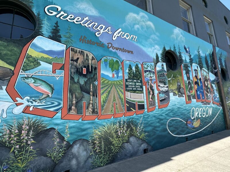 A colorful mural depicts plants, animals, water and "Grants Pass" in large lettering