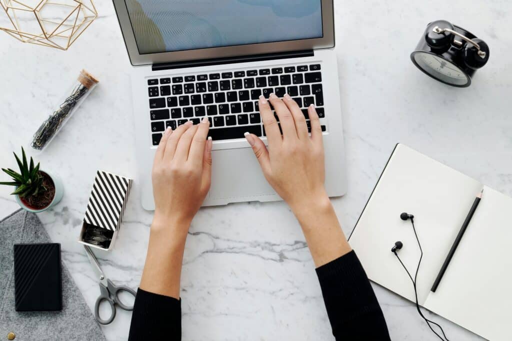 pexels-luna-lovegood-4087181 A woman's hands type on a laptop keyboard