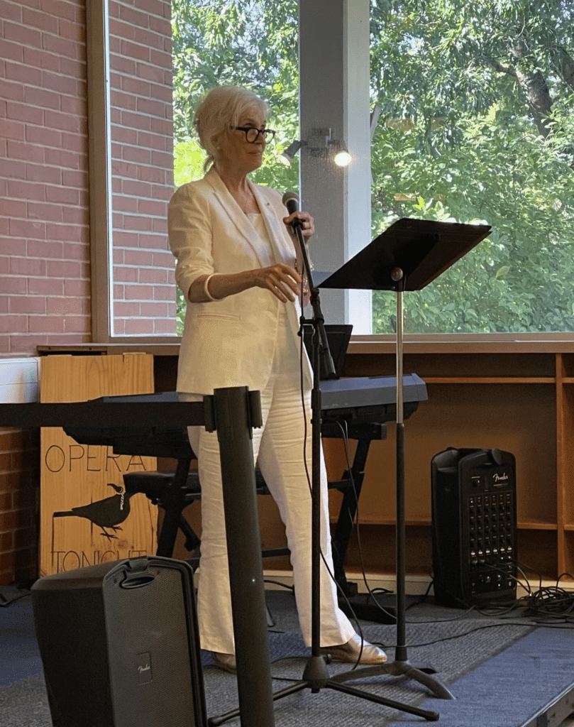 theARTScentered - A woman speaks into a microphone outside
