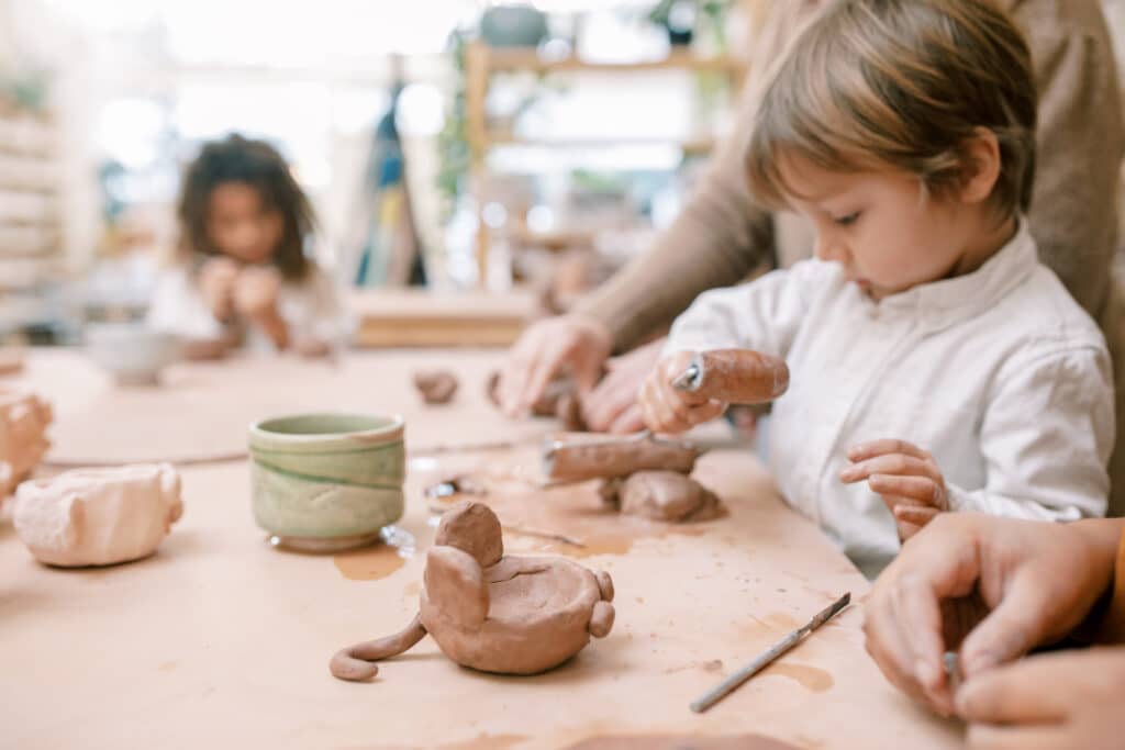 A child makes a sculpture out of clay. Art Spaces in Vancouver.